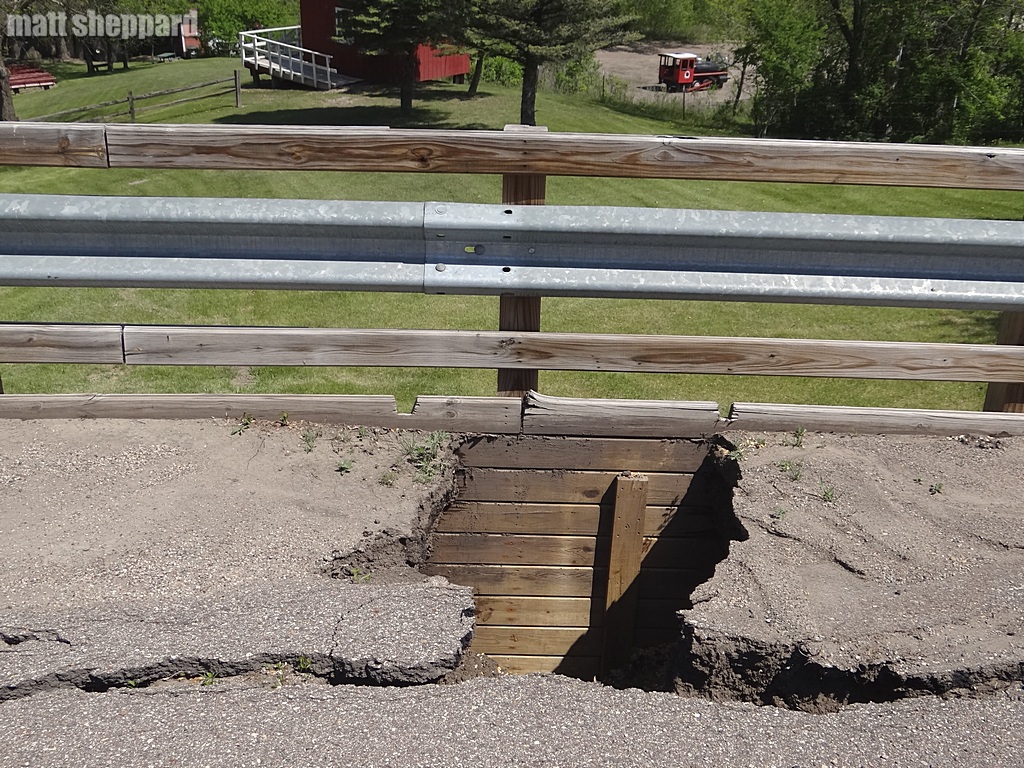 Soil beneath the pavement eroding, creating hole. 